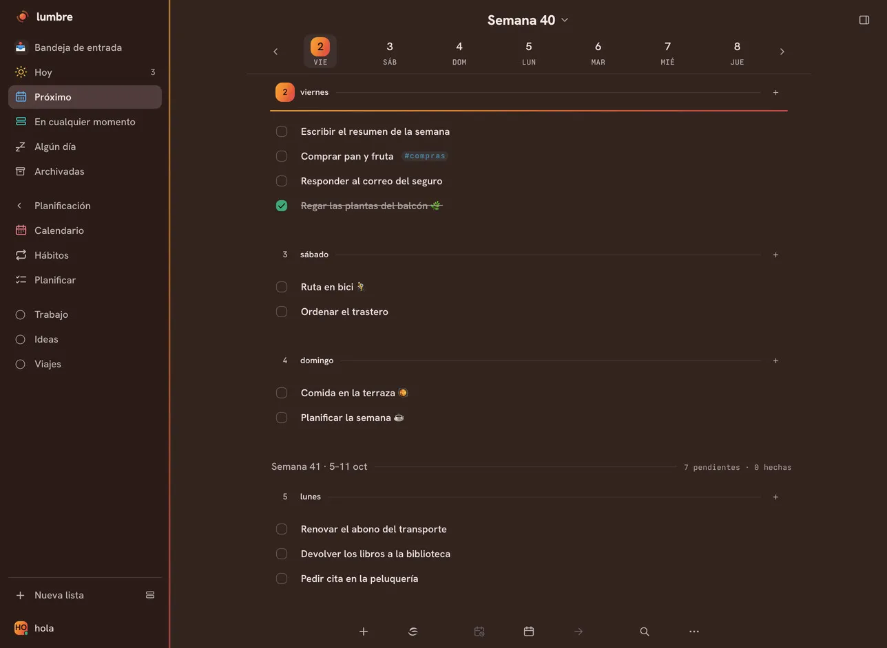 Vista Próximo de Lumbre en semana apilada, con el tema Brasa oscuro: la barra lateral con Bandeja de entrada, Hoy, Próximo, En cualquier momento, Algún día y Archivadas, la sección Planificación (Calendario, Hábitos, Planificar) y las listas Trabajo, Ideas y Viajes, y el lienzo de la semana 40 con viernes 2, sábado 3 y domingo 4, cada día con sus tareas y una ya tachada, y debajo la semana 41.